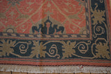 Corner detail of the vintage Soumac carpet showing the navy border and original ivory fringe.