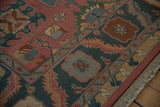 Vintage Soumac rug corner: serrated border, cartouche motif, dusty teal, rose, and fringe.