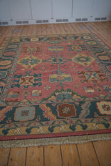 Soft fringed end and serrated border in teal, rose, saffron on a vintage Soumac design carpet.
