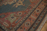 Vintage Soumac rug's madder root red border with serrated leaf motifs, dusty teal field, and fringe.