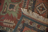 Beige fringe, woven side cord, and serrated leaf motifs on a vintage Serapi rug.