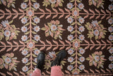 Vintage chainstitch rug's curvilinear floral trellis on dark chocolate, dusty blue, mauve.