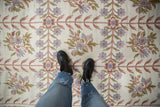 Vintage chainstitch carpet's ivory field with a flowing trellis of dusty rose and blue florals.