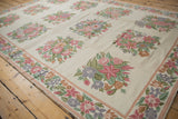 Curvilinear pink, lavender, and green floral bouquets with ornate border on a vintage chainstitch rug.
