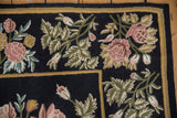 Vintage chainstitch carpet corner with raspberry floral bouquets and a striped gold and green border.