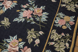 Textured chainstitch weave with blush floral sprays and gold stripe on a navy blue vintage carpet.