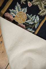 The sturdy cotton canvas backing of the vintage chainstitch carpet, seen from a folded corner.