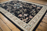 Corner of the vintage chainstitch rug with curvilinear floral motifs and geometric beige border.