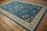 Turquoise chainstitch carpet with curvilinear Arts and Crafts floral motifs and patterned beige border.