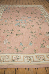 Close-up of vintage chainstitch rug's geometric border and rose curvilinear floral details.