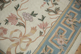 Arts and Crafts chainstitch rug detail: curvilinear blush florals and slate blue border.
