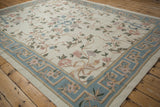 Slate blue Arts and Crafts border and curvilinear floral motifs on an ivory chainstitch rug.