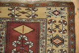 A vintage Melas rug corner with full pile, quatrefoil pinwheel blossoms, and multi-banded borders.