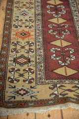 Angled view of the vintage runner contrasting the ivory border with pinwheel motifs and the copper central field.