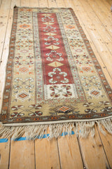 Low angle view down the length of a vintage Melas runner with copper and beige geometric patterns.