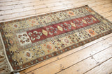 Angled view of a vintage Melas runner showing its full length and geometric pattern in copper and beige.