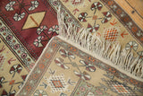 The clean hand-knotted foundation and intact ivory fringe on a vintage Turkish Melas rug corner.