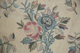 Curvilinear chainstitch floral bouquet in pastel blush and blue, on a spiraling ivory field.