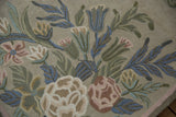 Detailed chainstitch weaving with curvilinear floral and leaf motifs in denim blue, rose, and green.