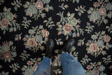Colonial-inspired black chainstitch carpet with blush, celadon floral sprays.
