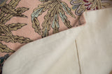 Vintage chainstitch rug, detailed curvilinear pattern on pink, revealing its sturdy cotton canvas backing.