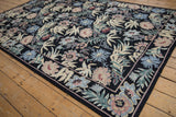 Black vintage chainstitch rug corner, with curvilinear florals in blush, seafoam, and denim.