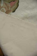 Cotton canvas backing of a vintage chainstitch carpet, with perimeter stitching and subtle floral edge.