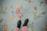 Vintage chainstitch carpet featuring curvilinear floral sprays and spiraling powder blue background.