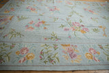Vintage Chainstitch carpet with curvilinear floral sprays and scrolling tendrils in pastels on light blue.