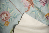 Stitched cotton canvas backing and powder blue chainstitch rug with pink floral motifs.