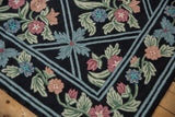 Textural chainstitch weave with curvilinear floral sprays and light blue trellis on black.