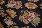 Chainstitch texture detail: cherry red, mauve, saffron floral motifs on a black ground.