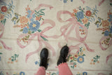 Vintage Chainstitch rug, curvilinear floral bouquets, pink ribbons on ivory ground.