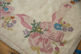 Ivory chainstitch rug with blush, sky blue, mauve curvilinear floral design.