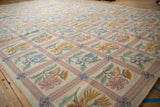 Curvilinear floral sprays in sky blue, saffron, and pale green within a dusty rose lattice.