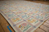 Curvilinear floral and vine motifs in the trellis pattern of a vintage chainstitch rug.