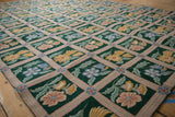 Emerald green chainstitch carpet features dusty rose trellis and colorful floral motifs.