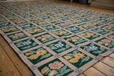 Chainstitch texture highlights dusty rose trellis and colorful floral motifs on emerald green.