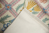 Cotton canvas backing of a vintage chainstitch carpet with ivory, pink, and blue floral details.