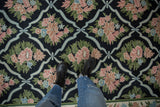 Chainstitch rug detail showing curvilinear trellis, blush, powder blue, and green floral motifs.