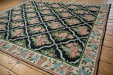 Vintage chainstitch carpet with a navy black field, curvilinear dusty blush floral sprays, and coordinating border.