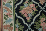 Curvilinear trellis pattern on a vintage chainstitch rug, with blush, blue, and green floral motifs.