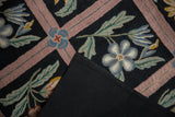 Black cotton canvas backing and intricate curvilinear chainstitch pattern.
