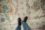 Ivory vintage chainstitch rug with Savonnerie style curvilinear florals, dusty pastels, and spiraling texture.