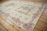 Curvilinear pink ribbon border with pastel floral motifs on a vintage Chainstitch carpet.