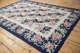 Curvilinear floral design on vintage chainstitch carpet in cobalt blue, ivory, and rose.