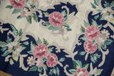 Vintage chainstitch carpet with Rococo-inspired curvilinear florals, spiraling ivory texture.