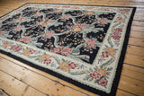 Detailed view of vintage chainstitch rug: pink roses, ribbons, and scrolling floral vines.