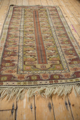 Secured light fringe and stylized plum, rust, olive borders of the Melas rug.
