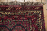 Deep raspberry borders, beige floral motifs, and soft fringe on vintage Daulatabad rug corner.